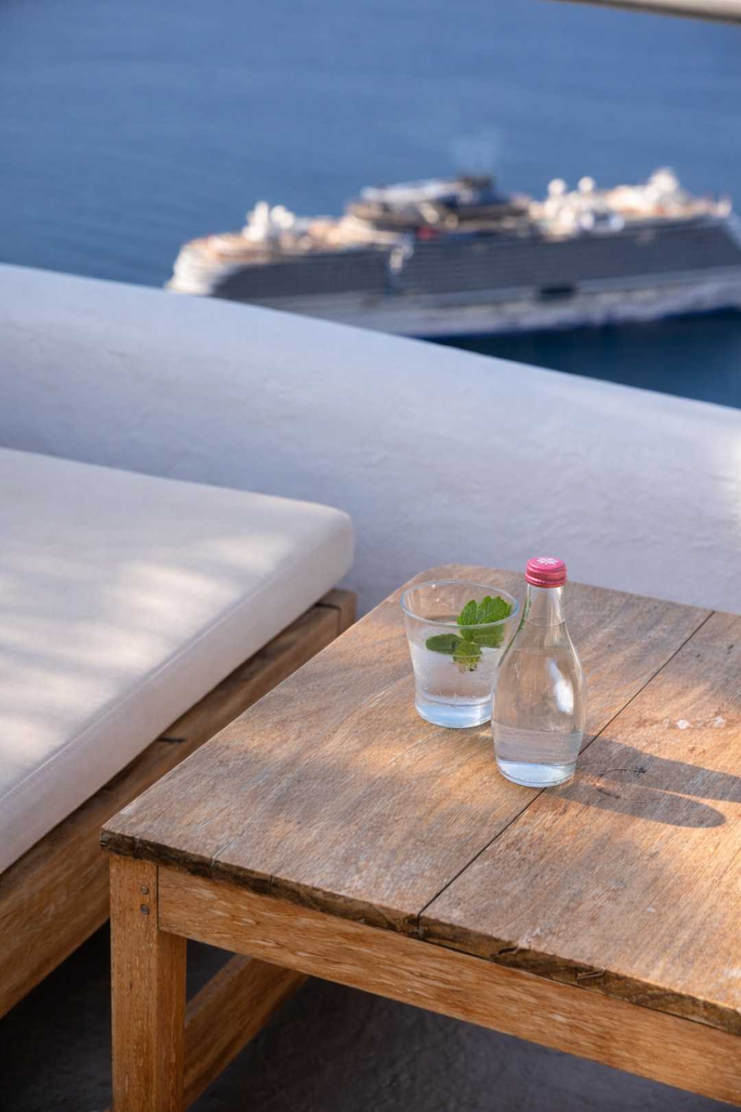 Terrace lounge area with mineral water and caldera backdrop