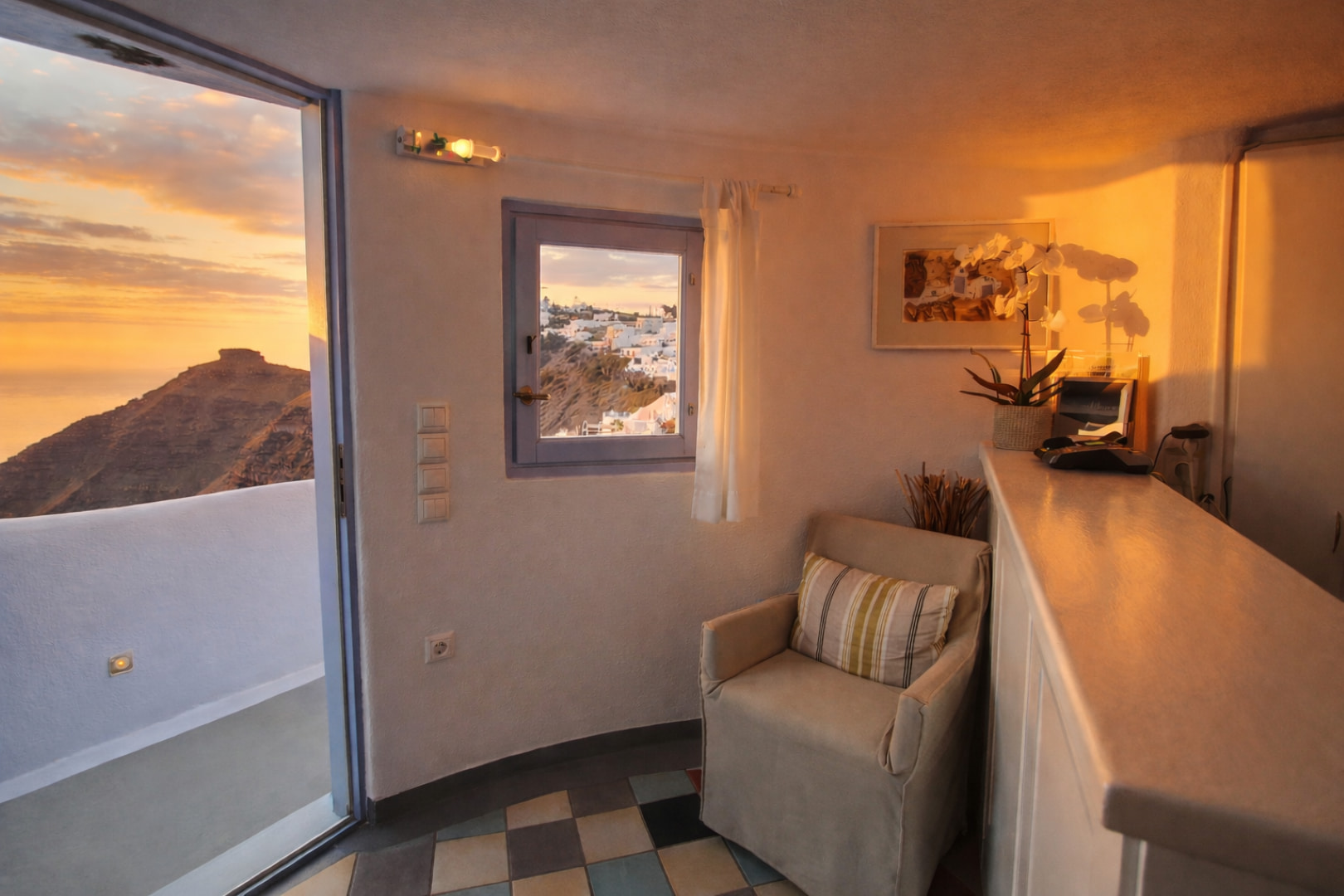 Reception Ikastikies Cozy interior corner with armchair and village view in Santorini