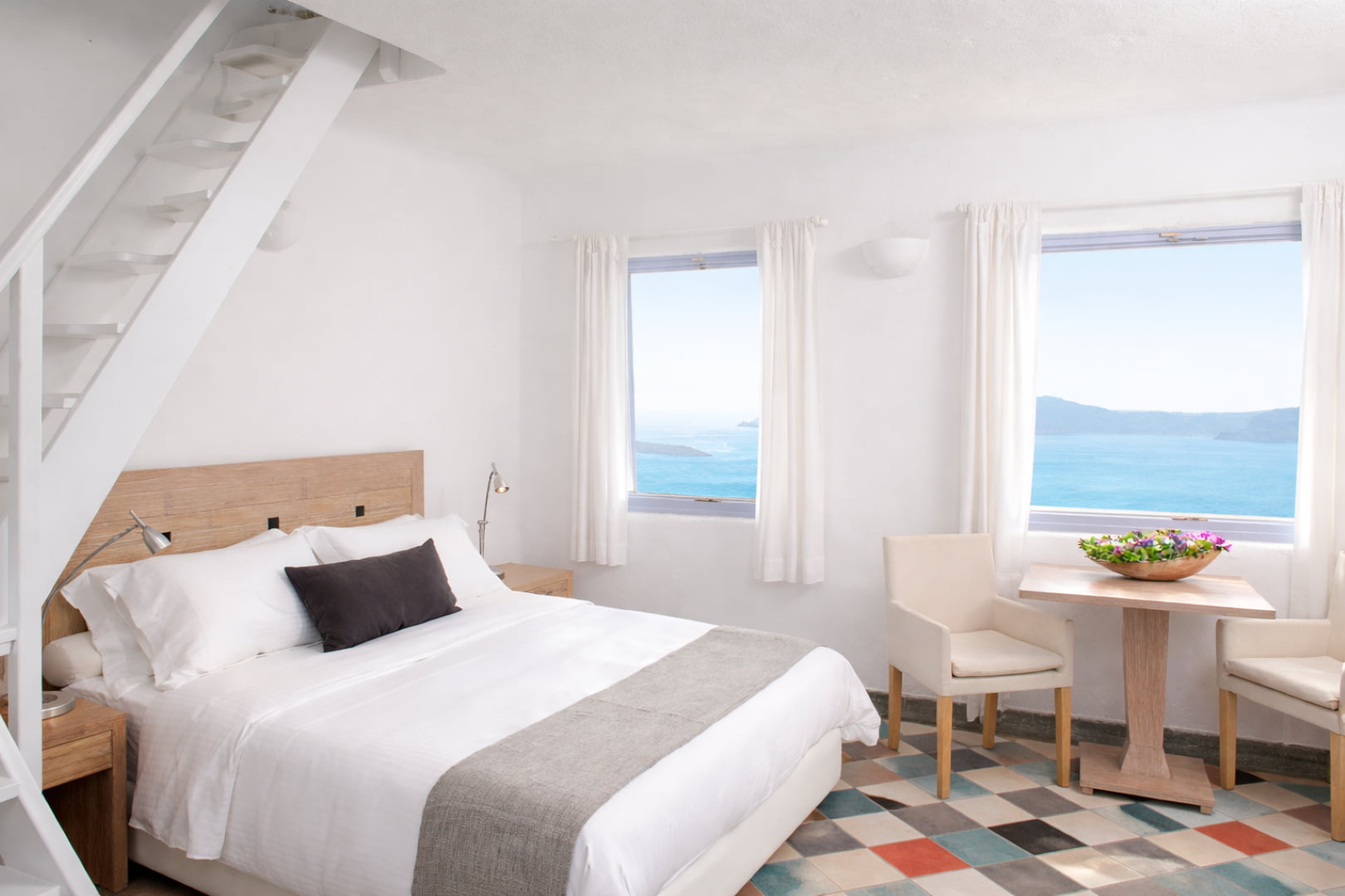 Minimal white bedroom with caldera sea view in Santorini boutique suite